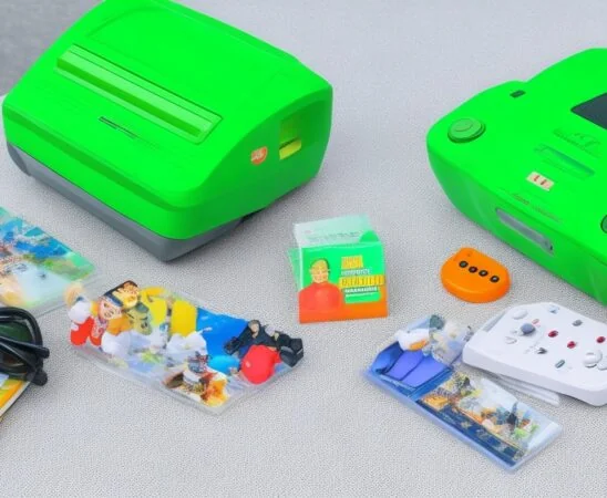 Ein sonnendurchfluteter, heller Arbeitsplatz mit einem Nintendo 64 und dem charakteristischen grünen Expansion Pak, umgeben von nostalgischen Spielekassetten und dezenten technischen Details, die eine warme, einladende Atmosphäre voller Erinnerung und Innovationsgeist ausstrahlt.