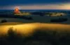 Ein strahlend heller, natürlicher Außenblick auf eine hochmoderne Kampfdrohne im Flug über sanft beleuchteter, friedlicher Landschaft, die mit warmem Sonnenlicht durchflutet ist und zugleich die spannende Verbindung von fortschrittlicher KI-Technologie und der ernsthaften Realität moderner Kriegsführung widerspiegelt.