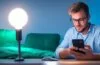 Ein freundliches, natürlich beleuchtetes Büroambiente, in dem eine lächelnde Person konzentriert auf einem modernen Smartphone die WhatsApp-Einstellungen prüft, umgeben von warmen Holztönen und hellem Tageslicht, das eine einladende und vertrauensvolle Atmosphäre schafft.