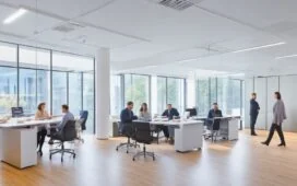 Ein lichtdurchflutetes, modernes Büro mit einem freundlichen Team, das an vernetzten Bildschirmen konzentriert und zugleich entspannt über innovative KI-gesteuerte Geschäftsprozesse diskutiert – strahlende Gesichter, natürliche Farben und eine warme Atmosphäre spiegeln Optimismus und technologische Zukunftskraft wider.