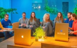 Eine helle, freundliche Büroszene mit einem vielseitigen UX-Team in lebhaftem Austausch, umgeben von Notizen, Skizzen und Laptop-Bildschirmen, die durch warmes Tageslicht natürlich erleuchtet und von einer modernen, offenen Arbeitsatmosphäre mit klarem Fokus auf kreative Produktentwicklung geprägt ist.