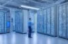 In einem modernen, lichtdurchfluteten Serverraum strahlt ein IT-Administrator mit einem warmen Lächeln vor mehreren hochmodernen Monitoren und offenen Serverracks, die mit dezenten LED-Leuchten sanft beleuchtet sind, während die natürliche Tageslichtatmosphäre eine einladende und professionelle Umgebung für innovative Open-Source-Virtualisierung vermittelt.