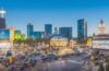In einem hellem, modern gestalteten Konferenzraum in Las Vegas diskutieren leidenschaftliche IT-Sicherheitsexperten in natürlichem Tageslicht konzentriert und hoffnungsvoll um einen großen Holztisch, umgeben von Laptops und digitalen Visualisierungen, die den Wandel zu sicherer Software verkörpern – ein warmes, inspirierendes Bild voller Energie und kollegialem Austausch.