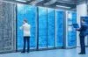 Ein sonnendurchfluteter Technikraum mit modernen Serverracks, in dem ein lächelnder IT-Ingenieur mit entspanntem Blick an einem Laptop arbeitet, umgeben von warmem, natürlichem Licht und einer Atmosphäre von Innovation, Nachhaltigkeit und zukunftsweisender Vernetzung.