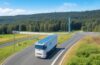 Ein strahlend sonnendurchfluteter, moderner Elektro-Lkw rollt dynamisch auf einer weitläufigen Autobahn, umgeben von grünen Feldern und klarem Himmel, während im Hintergrund eine elektrische Güterbahn vorbeirollt – ein warmer, optimistischer Moment, der den Weg in eine nachhaltige Zukunft des Schwerlastverkehrs symbolisiert.