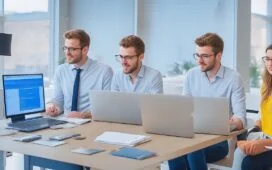 Ein warmes, lichtdurchflutetes Büro mit einem jungen Entwicklerteam in moderner, offener Arbeitsumgebung, das konzentriert und motiviert gemeinsam an Laptops und Bildschirmen arbeitet, um die Zukunft innovativer Webtechnologien zu gestalten.