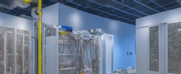 Ein hell erleuchteter, moderner Serverraum mit sanft warmem Tageslicht, in dem Technik-Experten konzentriert und freundlich an hochmodernen, energieeffizienten Rechenzentrumssystemen arbeiten, umgeben von schlanken Kühlanlagen und fein abgestimmter Sensorik, die das zukunftsweisende Zusammenspiel von Nachhaltigkeit und Digitalisierung bildhaft vermittelt.