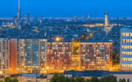 Helles, stimmungsvolles Editorial-Foto eines modernen Rechenzentrums im urbanen Frankfurter Umfeld bei sanftem Tageslicht, das durch große Panoramafenster flutet, mit Fokus auf technische Details wie Serverracks und Kabelbündel, während im Hintergrund die Silhouette der Mainmetropole warm leuchtend zu erkennen ist und so die Spannung zwischen digitalem Fortschritt und Energieherausforderung eindrucksvoll vermittelt wird.