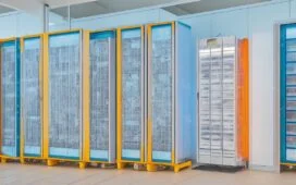 Eine dynamische Szene in einem modern ausgestatteten Rechenzentrum: Eine selbstbewusste Frau mittleren Alters steht lächelnd zwischen leuchtenden Serverracks, während das warme Tageslicht sanft durch große Fenster fällt und ihre engagierte Präsenz als unsichtbare Schlüsselkraft der digitalen Zukunft strahlt.