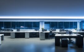 Ein hell erleuchtetes modernes Büro mit konzentriert lächelnden IT-Sicherheitsexperten vor mehreren Bildschirmen, die in natürlichem Tageslicht arbeiten und eine Atmosphäre von Vertrauen, Wachsamkeit und Gemeinschaft schaffen.