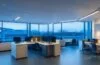Ein gemütlich hell erleuchtetes Büro mit zwei Programmierern, die lächelnd konzentriert vor modernen Laptops mit offener Code-Software sitzen, während warmes Tageslicht durch große Fenster strömt und die freundliche Atmosphäre einer kreativen Zusammenarbeit mit KI-gestützter Technologie einfängt.