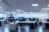 Ein klar erleuchtetes, modernes Büro mit konzentrierten IT-Experten vor mehreren Bildschirmen, die in warmer Tageslichtstimmung zusammen an komplexen Cyber-Sicherheitsanalysen arbeiten, während die Atmosphäre durch freundliche Gesichter und natürliche Details eine professionelle, zugleich menschlich vertraute Stimmung vermittelt.