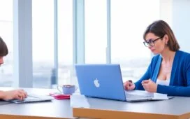 Eine freundliche, helle Büroatmosphäre mit einer konzentrierten Person mittleren Alters vor einem modernen Laptop, die achtsam ihre E-Mails auf Sicherheitslücken prüft, warmes natürliches Tageslicht fällt sanft durch große Fenster und schafft eine einladende, vertrauensvolle Stimmung.