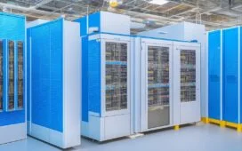 Ein sonnendurchfluteter, moderner Rechenzentrum-Serverraum mit glänzenden KI-Chips und vernetzten Kabelbündeln, in dem Technikexperten mit freundlichen Gesten die komplexe Infrastruktur prüfen und den Wandel zu nachhaltiger, intelligenter Technologie voller Zuversicht gestalten.