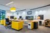 Ein warm beleuchtetes, modernes Büro mit lächelnden Webdesigner:innen und SEO-Spezialisten, die konzentriert an großen Bildschirmen mit klar strukturierten Webseitenlayouts arbeiten, wobei Tageslicht durch große Fenster fällt und eine freundliche, produktive Atmosphäre schafft.