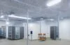Ein warm ausgeleuchteter, moderner Serverraum mit klar strukturierten Elektroinstallationen und leuchtenden Kontrolllampen, in dem technisches Fachpersonal aufmerksam und konzentriert die Sicherheitsstandards der VDE-Normen überprüft, eingebettet in eine harmonische Atmosphäre aus natürlichem Tageslicht und funktionaler Eleganz.