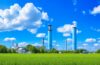 Eine sonnenbeschienene, moderne Industrieanlage in Sachsen-Anhalt, vor einem klaren blauen Himmel, mit grünen Flächen und Solarzellen im Vordergrund, die durch warmes, natürliches Licht eine einladende Atmosphäre voller Zukunftsoptimismus und digitaler Transformation ausstrahlt.