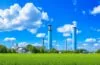 Eine sonnenbeschienene, moderne Industrieanlage in Sachsen-Anhalt, vor einem klaren blauen Himmel, mit grünen Flächen und Solarzellen im Vordergrund, die durch warmes, natürliches Licht eine einladende Atmosphäre voller Zukunftsoptimismus und digitaler Transformation ausstrahlt.