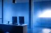 In einem hell erleuchteten, modernen Büro sitzt eine freundliche Frau entspannt vor ihrem Laptop, während sanftes Tageslicht durch große Fenster fällt und eine warme, vertrauensvolle Atmosphäre schafft, die das Thema Cybersicherheit und Schutz vor Phishing-Angriffen subtil widerspiegelt.