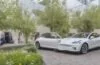 Ein sonnendurchfluteter, moderner Elektroauto-Ausstellungsraum in einer europäischen Stadt, in dem ein glänzendes Tesla Model Y in klaren, realistischen Details vor lebendig grünen Pflanzen steht, während freundliche Menschen entspannt mit einem Verkäufer ins Gespräch vertieft sind und die warme, natürliche Lichtstimmung Hoffnung und Wandel in der europäischen Elektromobilität ausstrahlt.
