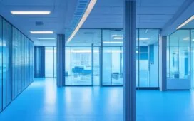 In einem hell erleuchteten, modernen Kontrollraum arbeiten zwei fokussierte IT-Spezialisten an mehreren Bildschirmen mit komplexen Sicherheitsgrafiken, während warme Sonnenstrahlen durch große Fenster fallen und eine Atmosphäre von Vertraulichkeit, Teamgeist und digitaler Entschlossenheit schaffen.