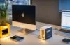Helles, freundlich illuminiertes Büro mit modernem Mini-PC auf einem klaren Schreibtisch, umgeben von warmen Holzakzenten und sanftem Tageslicht, während eine konzentrierte Person die innovative KI-Technologie nutzt und so die zukunftsweisende Verbindung von kompakter Hardware und digitalem Fortschritt im Arbeitsalltag verkörpert.