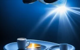 Ein strahlend hell ausgeleuchteter, natürlicher Moment zeigt ein schlankes iPhone Air auf einer stilvollen Holzoberfläche, umgeben von subtilen Alltagselementen wie einer geöffneten Notiz und einer Tasse Kaffee, das Licht reflektiert sanft auf dem glatten Titan-Gehäuse und vermittelt eine warme, einladende Atmosphäre voller Eleganz und Alltagstauglichkeit.