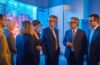 Ein hell beleuchteter, freundlicher Besprechungsraum mit engagierten Personen verschiedener Generationen und Hintergründe, die bei warmem Tageslicht konzentriert und respektvoll eine Diskussion über digitale Datenschutzthemen führen, während moderne Technik und Dokumente auf dem Tisch lebendige Einblicke in die komplexe Debatte um KI-Verordnung und Grundrechte vermitteln.