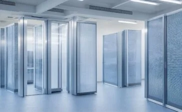 In einem modernen Rechenzentrum strahlt warmes Tageslicht durch große Fenster, während technikaffine Fachleute konzentriert an hochmodernen Serverracks arbeiten und so den lebendigen Geist von Innovation und nachhaltigem Fortschritt in der digitalen Infrastruktur verkörpern.