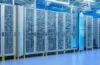 Ein warm beleuchtetes, modernes Rechenzentrum mit eleganten Serverracks, in dem ein Team konzentriert an der Schnittstelle zwischen klassischen Computern und einer futuristischen Quantenhardware arbeitet, während sanftes Tageslicht durch große Fenster fällt und die innovative, harmonische Symbiose von Technologie und Menschlichkeit unterstreicht.