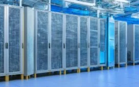 Ein warm beleuchtetes, modernes Rechenzentrum mit eleganten Serverracks, in dem ein Team konzentriert an der Schnittstelle zwischen klassischen Computern und einer futuristischen Quantenhardware arbeitet, während sanftes Tageslicht durch große Fenster fällt und die innovative, harmonische Symbiose von Technologie und Menschlichkeit unterstreicht.