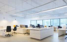 Strahlend beleuchtetes, modernes Büro mit entspannt lächelnden UX-Designer:innen, die an hellen Bildschirmen interaktives Prototyping und nutzerzentriertes, aufgeräumtes Interface-Design besprechen, umgeben von natürlichen Materialien und warmem Tageslicht, das eine freundliche, einladende Atmosphäre schafft.