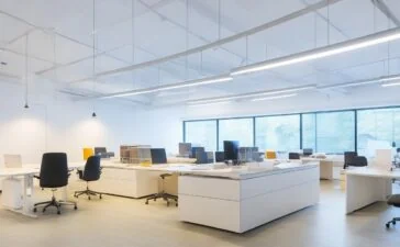 Strahlend beleuchtetes, modernes Büro mit entspannt lächelnden UX-Designer:innen, die an hellen Bildschirmen interaktives Prototyping und nutzerzentriertes, aufgeräumtes Interface-Design besprechen, umgeben von natürlichen Materialien und warmem Tageslicht, das eine freundliche, einladende Atmosphäre schafft.