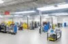 Ein strahlender Morgen über einer modernen Rechenzentrum-Anlage mit weitläufigen, nachhaltig gestalteten Gebäuden und sanfter natürlicher Beleuchtung, während freundliche Mitarbeitende in Business-Kleidung entspannt im Vordergrund stehen und den Fortschritt eines innovativen Joint Ventures voller Hoffnung und Zukunftsvision symbolisieren.