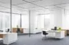 Ein warm erleuchtetes, modernes Büro mit einem konzentrierten Forscher, der vor einem Bildschirm sitzt, auf dem komplexe Daten und Diagramme schemenhaft zu erkennen sind – das natürliche Licht flutet durch große Fenster und schafft eine freundliche, einladende Atmosphäre, die den Innovationsgeist und die Hoffnung auf technologische Lösungen für die Herausforderungen von KI-Halluzinationen widerspiegelt.