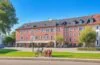 Sonnendurchflutetes Stadtbild mit modernen Glasfaserkabeln, die dynamisch von Handwerkern verlegt werden, während im Hintergrund Familien entspannt im Grünen zusammenarbeiten und digitale Geräte nutzen – ein harmonisches Zusammenspiel von Fortschritt, Gemeinschaft und digitaler Zukunft unter strahlend blauem Himmel.