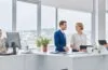 Ein sonnendurchflutetes, modernes Büro mit warmen Holztönen, in dem ein Team junger Entwickler konzentriert an Laptops arbeitet und dabei mit einem Tablet die nahtlose Integration von Cloud-Technologien und Desktop-Apps visualisiert – die Szene strahlt lebendige Zusammenarbeit, technologische Innovation und freundliche Produktivität aus.