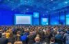 Ein hell erleuchteter, moderner Konferenzraum mit zwei Business-Teams in entspannten Gesprächen, die bei natürlichem Tageslicht neue Partnerschaftideen zwischen OpenAI und Microsoft mit einem warmen, kollegialen Flair austauschen.