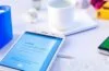 Ein sonnenbeschienener, moderner Arbeitsplatz mit einem entspannt lächelnden Menschen, der auf seinem Android-Smartphone in den hellen, klaren Einstellungen den Private-DNS-Modus aktiviert, umgeben von warmem Tageslicht und natürlichen Details, die digitale Sicherheit und vertrauliche Technik harmonisch verbinden.
