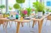 Ein sonnendurchfluteter Schreibtisch mit modernen Smartphones, auf denen lebendige Kameraoberflächen und elegante Designs glänzen, umgeben von Pflanzen und warmem Holz, vermittelt Innovation, Nachhaltigkeit und zukunftsweisende Technik in einem hellen, einladenden Ambiente.