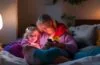 Ein warmes, natürlich beleuchtetes Portrait einer sorgenden Mutter und ihres Kindes, die gemeinsam auf ein Smartphone schauen, während sie in einem hellen, gemütlichen Wohnzimmer sitzen – die Atmosphäre strahlt Vertrauen, Nähe und den achtsamen Umgang mit digitaler Mediennutzung aus.