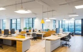 Ein warm beleuchtetes, modernes Büro mit einem konzentrierten Mitarbeiter vor mehreren Bildschirmen, die Daten und Online-Shopping-Statistiken in natürlichem Tageslicht zeigen – Sinnbild für die KI-gesteuerte dynamische Preisgestaltung im E-Commerce.
