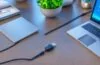 In einem hellen, modern eingerichteten Arbeitszimmer liegt ein silberglänzendes Laptop mit offenem USB-C-Anschluss neben einem eleganten Tablet, das mit einem magnetischen Smart Connector verbunden ist, während warmes Tageslicht sanft durch ein großes Fenster fällt und die glatten Oberflächen und fein gearbeiteten Details der Hightech-Geräte einladend betont.