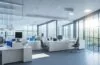 Ein lichtdurchflutetes, modernes Büro mit konzentrierten IT-Experten, die vor großen Bildschirmen mit komplexen Daten und Quantencomputern arbeiten, strahlt eine warme, einladende Atmosphäre aus, die technologische Innovation und kollaborative Zukunftssicherheit verbindet.