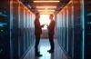 Ein warm beleuchteter, moderner Serverraum mit strahlend heller, natürlicher Beleuchtung, in dem zwei IT-Experten im Gespräch fokussiert über leistungsstarke Dell PowerStore-Hardware und Nutanix-Cloud-Lösungen stehen, umgeben von eleganter Technologie und einer Atmosphäre von zukunftsweisender Innovation und vertrauensvoller Partnerschaft.