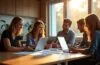 Ein lebendig strahlendes Team von Entwicklerinnen und Entwicklern sitzt bei natürlichem Tageslicht konzentriert und lächelnd an ihren modernen Laptops in einem hellen, freundlichen Büro mit warmen Holztönen und großen Fenstern, während kreative Skizzen und Code auf Tablets die spannende Dynamik der Transformation durch .NET 10 symbolisieren.