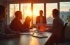 Ein hell erleuchtetes, modernes Büro mit jungen Fachleuten in angeregtem Gespräch vor großen Fenstern, die den aufkeimenden Wandel und die Chancen einer neuen technologischen Ära im Schein warmen Tageslichts einfangen.