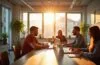 Ein strahlend helles Büro mit natürlichen Sonnenstrahlen, in dem ein engagiertes Entwicklerteam entspannt und konzentriert an modernen Laptops arbeitet, umgeben von klar strukturierten Notizen und einer freundlichen, warmen Atmosphäre, die Kreativität und professionelle Teamarbeit in der Webentwicklung symbolisiert.