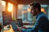 Ein modernes, hell erleuchtetes Büro mit einem konzentrierten IT-Experten, der an einem Laptop arbeitet, umgeben von warmem Tageslicht und sanften Holztönen, während im Hintergrund Bildschirme mit Code und Sicherheitssoftware dezent sichtbar sind und eine Atmosphäre von Verlässlichkeit und digitaler Vorsicht vermitteln.