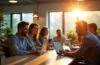 Ein lichtdurchflutetes, modernes Büro mit strahlenden Entwicklern und IT-Experten in lebendiger Teamarbeit vor offenen Laptops, umgeben von dezenten Pflanzen und warmen Holzakzenten, die die inspirierende Atmosphäre von Offenheit, Innovation und kollaborativer Technologie bei SAPs Weg in Open Source und Open AI verkörpern.